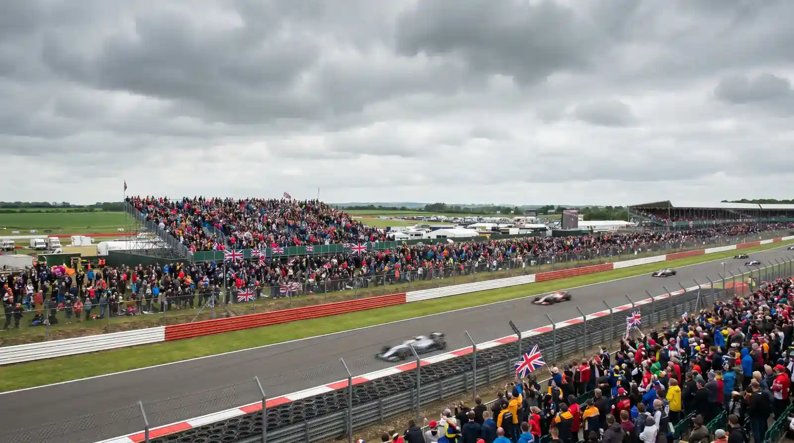 Packed grandstands at the British Grand Prix at Silverstone with F1 cars on track
